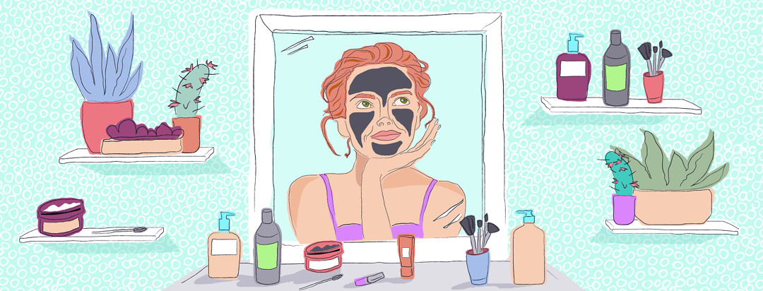 A woman is gazing into the mirror, wearing a charcoal face mask, and contemplating the next product to use. Her products are scattered about her vanity.