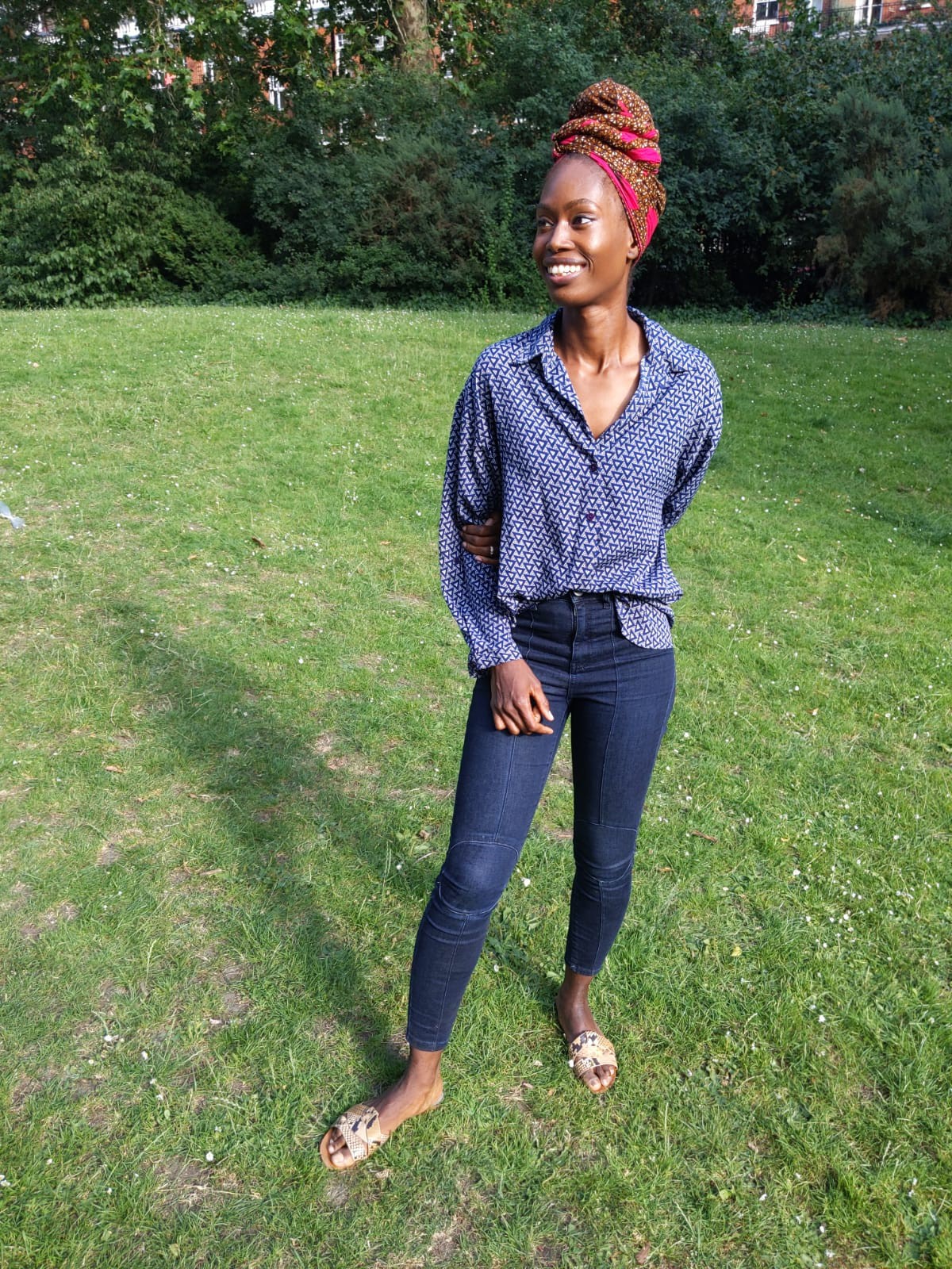 Joanne smiling and standing in a field of grass