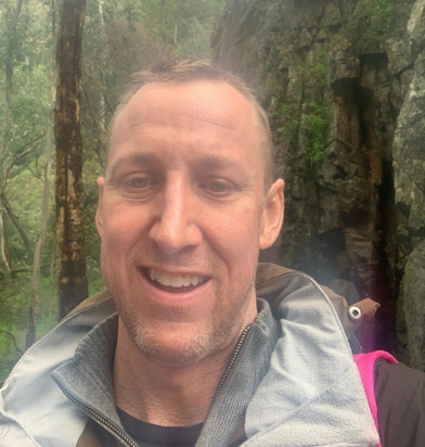 Chad smiles for a selfie in the woods