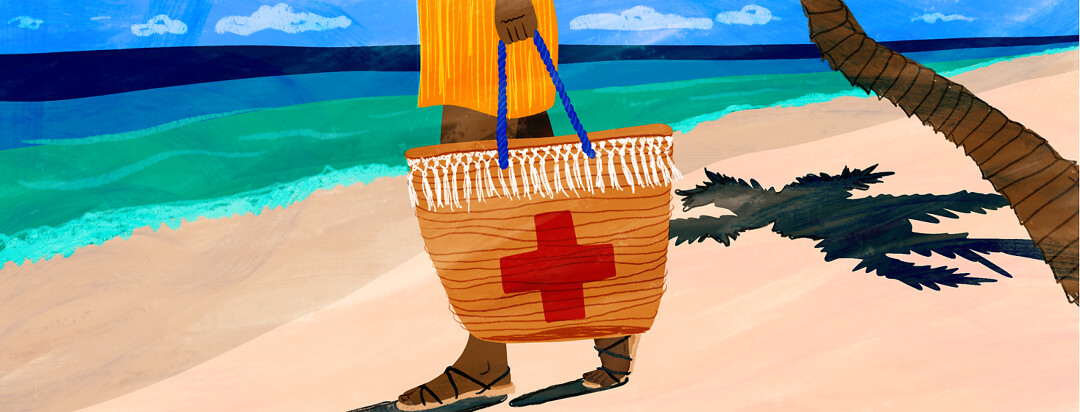 A woman walks down the beach holding a beach bag with a red cross on it.