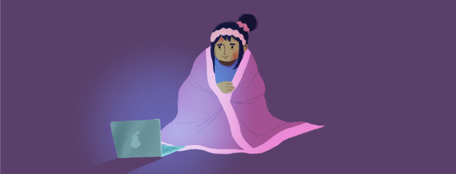 Adult female covered in a blanket is watching a tv show on her laptop and finding comfort in it. Relaxation, television, video streaming. POC