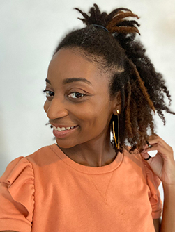 Side view of atopic dermatitis advocate Raelle, smiling.