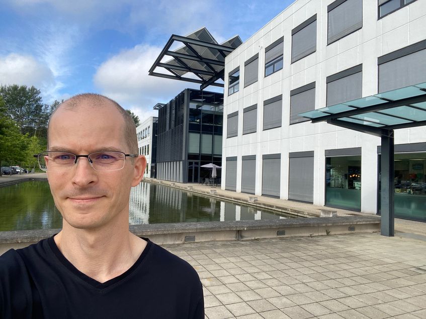 Poul stands in front of a modern building