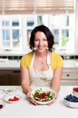 Jennifer holds a bowl of salad in her kitchen