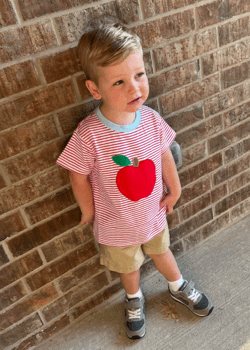 Photo of a child standing against a wall