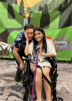 Photo of a man and a woman standing together, the woman is in a wheelchair