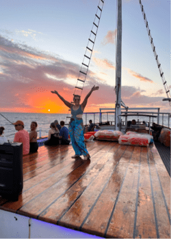 Photo of someone posing on a cruise in front of the sunset